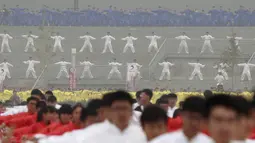 Ribuan orang melakukan pertunjukan bela diri Taichi di salah satu lapangan sekolah di Provinsi Henan, Cina, Minggu (18/10/2015). Pertunjukan ini diselenggarakan di 15 lokasi yang berbeda. (REUTERS/Stringer)