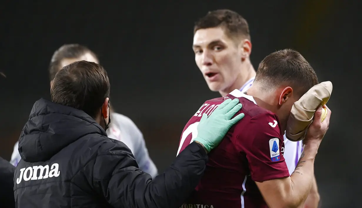 Pemain Torino Andrea Belotti (kanan) usai dia bertabrakan dengan pemain Fiorentina Nikola Milenkovic (kedua kanan belakang) pada pertandingan Liga Italia di Olympic Stadium, Turin, Italia, Jumat (29/1/2021). Fiorentina berhasil menahan imbang Torino 1-1. (Fabio Ferrari/LaPresse via AP)