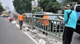 Pekerja dari Dinas Perhubungan DKI Jakarta melakukan pemasangan pagar pembatas jalan di Jalan HOS. Cokroaminoto, Jakarta, Selasa (6/11). Pemasangan pagar pembatas ini mengantisipasi kecelakaan di jalan tersebut. (Merdeka.com/ Iqbal S. Nugroho)