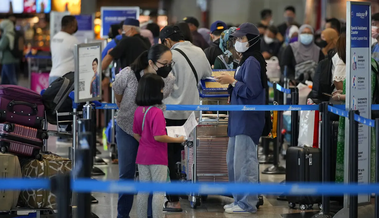 Pelancong mengantre di konter check-in Bandara Internasional Kuala Lumpur, Sepang, Malaysia, Jumat (1/4/2022). Mulai hari ini, Malaysia membuka perbatasannya untuk orang asing dan pelancong yang sudah divaksin COVID-19 lengkap tanpa harus menjalani karantina. (AP Photo/Vincent Thian)
