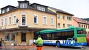 Bus sekolah terparkir di depan bangunan setelah menabrak tembok sebuah toko di Eberbach dekat Mannheim, Jerman, Selasa (16/1). Setidaknya 48 orang terluka dalam kecelakaan bus yang membawa anak-anak sekolah tersebut. (Uwe Anspach/dpa via AP)