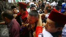 Ekspresi seorang pria yang diduga provokator diamankan dari amukan massa saat sidang kasus penistaan agama di Jakarta, Selasa (10/1). Sempat terjadi kericuhan akibat peristiwa tersebut. (Liputan6.com/Immanuel Antonius)