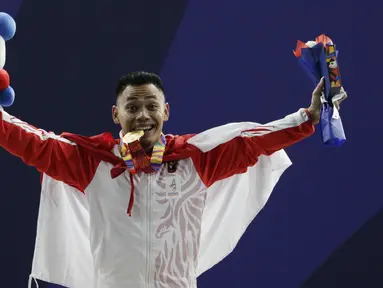 Lifter Eko Yuli melakukan selebrasi saat mendapatkan medali emas SEA Games 2019 cabang angkat besi nomor 61 kg di Stadion Rizal Memorial, Manila, Minggu (1/12). Dirinya meraih emas dengan total angkatan 309 kg. (Bola.com/M Iqbal Ichsan)