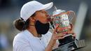 Petenis Polandia, Iga Swiatek, melakukan selebrasi mencium trofi usai menjuarai Grand Slam Prancis Terbuka di Paris, Sabtu, Sabtu (10/10/2020). Petenis berusia 19 tahun itu menaklukkan wakil Amerika Serikat, Sofia Kenin, dua set langsung 6-4 dan 6-1. (AP Photo/Michel Euler)