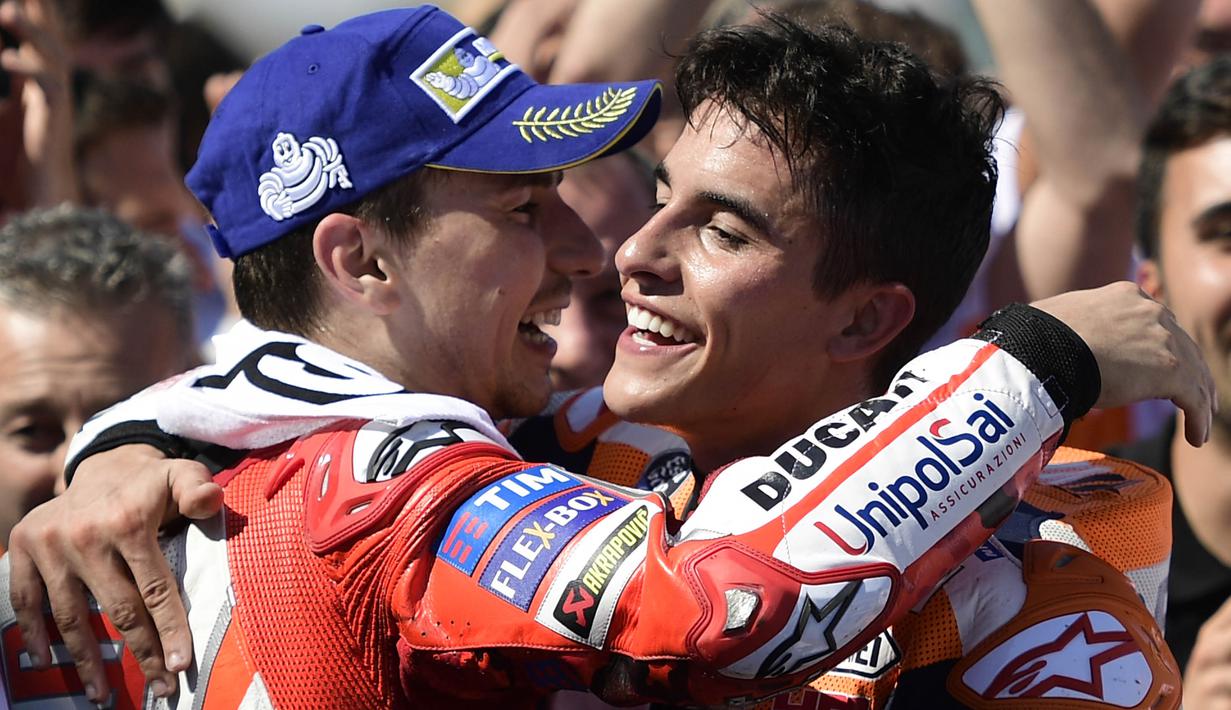 Pebalap Repsol Honda, Marc Marquez, bersama pebalap Ducati, Jorge Lorenzo, merayakan kemenangan pada GP Aragon di Sirkuit Motorland, Alcaniz, Minggu (24/9/2017). Marquez berhasil finis tercepat dengan waktu 42 menit 6,819 detik. (AFP/Jose Jordan)