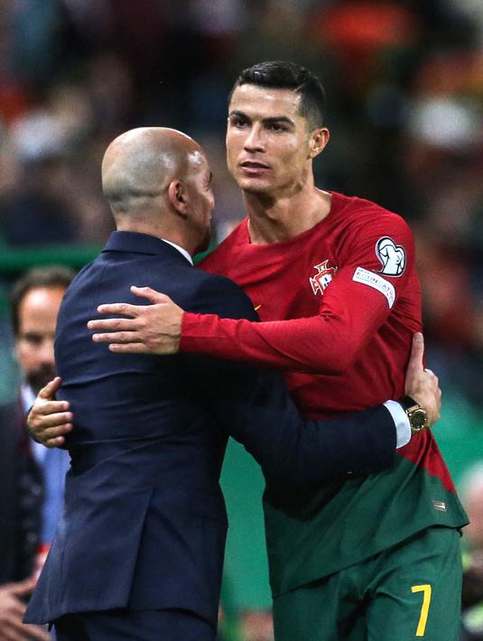 <p>Pemain Timnas Portugal, Cristiano Ronaldo (kanan) memeluk pelatihnya, Roberto Martinez pada laga Kualifikasi Euro 2024 melawan Timnas Liechtenstein yang berlangsung di Jose Alvalade, Lisboa, Portugal, Jumat (24/03/2023) dini hari WIB. CR7 berhasil menorehkan rekor baru sebagai pemain dengan torehan caps internasional terbanyak dalam sejarah. Lewat 197 penampilannya bersama Selecao, ia berhasil melewati rekor striker Kuwait, Bader Al-Mutawa yang sebelumnya memimpin dengan 196 caps. (AFP/Carlos Costa)</p>
