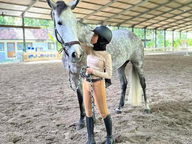 Lewat unggahan Instagram pribadinya, Lesti Kejora terlihat berpose dengan kuda yang ukuranya besar. Hal inilah yang membuat netizen salah fokus dengan tubuh Lesti Kejora yang dikenal mungil. (Liputan6.com/IG/@lestykejora).