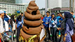 Sebuah maskot berbentuk kotoran ikut memeriahkan acara kampanye 'Toilet Sehat' saat Car Free Day (CFD) di Bundaran HI, Jakarta, Minggu (15/11/2015). (Liputan6.com/Yoppy Renato)