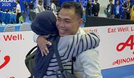 Weightlifter andalan Indonesia, Eko Yuli Irawan, mendapat pelukan dari sang istri, Masitah, setelah meraih medali perunggu di SEA Games 2025. Bertanding di Chon Buri Physical Education School, Chonburi, pada Minggu (14/12/2025) sore WIB, Eko kalah bersaing dari atlet Thailand dan Malaysia. (Bola.com/Muhammad Adi Yaksa)