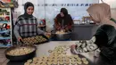 Kaak merujuk pada jenis roti populer yang biasa di kosumsi di seluruh Timur Tengah (Palestina, Lebanon, Suriah, Yordania). Tampak dalam foto, para wanita menyiapkan biskuit tradisional "kaak" yang berbentuk cincin menjelang Idul Fitri, hari raya yang menandai berakhirnya bulan puasa suci Ramadan, di Kota Gaza pada 16 Maret 2026. (Omar AL-QATTAA/AFP)
