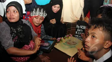 Keluarga dan sahabat saat mendoakan komedian Betawi Nur Sarinuri atau lebih dikenal Mpok Nori seusai dimakamkan di TPU Pondok Ranggon, Jakarta Timur, Jumat (3/4/2015). (Liputan6.com/Helmi Afandi)