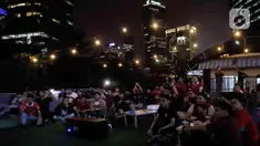 Warga menyaksikan pertandingan final cabang olahraga sepak bola SEA Games 2023 antara timnas Indonesia melawan Thailand di Green Cafe Semanggi, Jakarta, Selasa (16/5/2023). (Liputan6.com/Herman Zakharia)