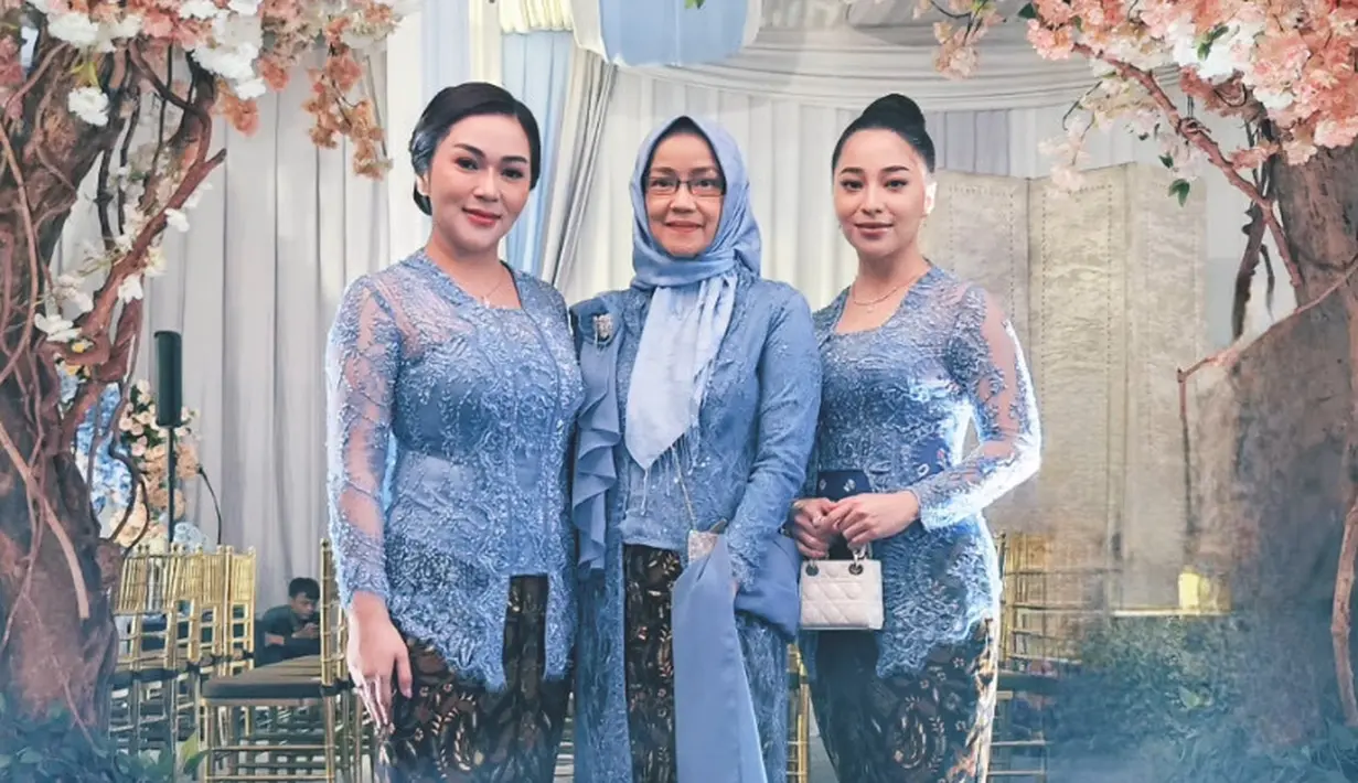 Nikita Willy tampil mengenakan kebaya brokat warna baby blue, dipadukan obi navy dan kain bawahan batik warna coklat. Sambil membawa mini bag Dior putih. [@herajusi]
