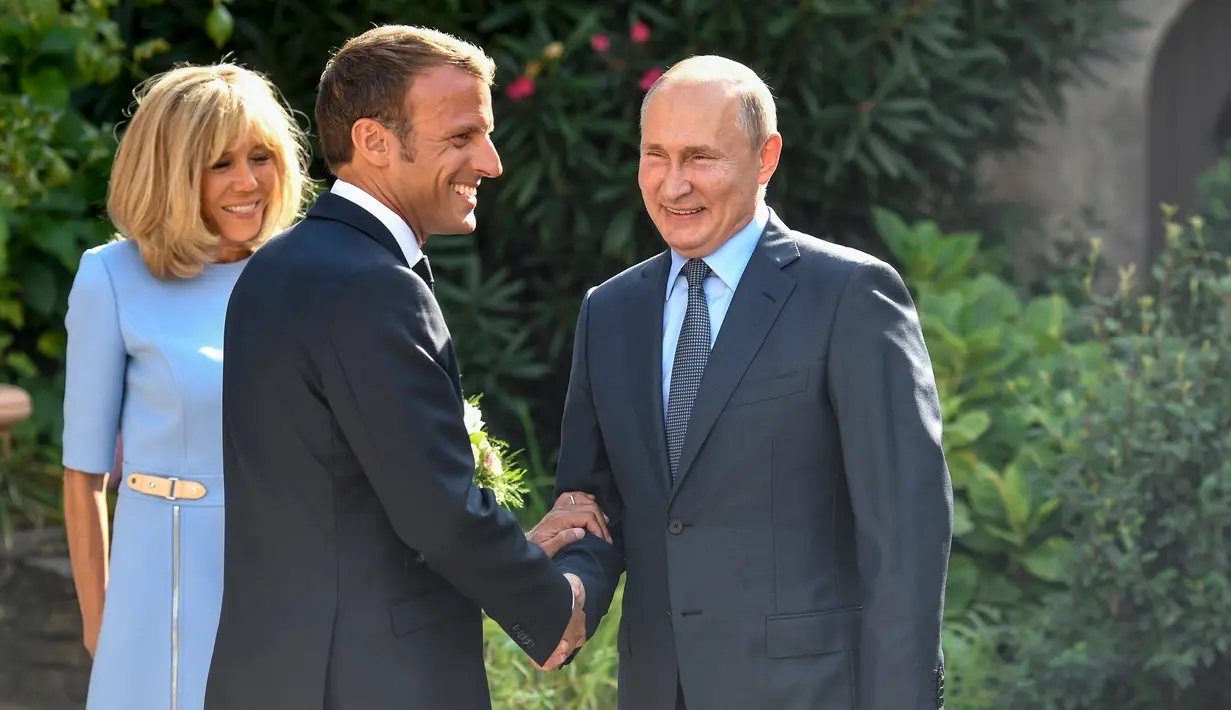 Presiden Prancis Emmanuel Macron (tengah) dan istrinya Brigitte (kiri) menyambut Presiden Rusia Vladimir Putin di Benteng Bregancon, Bormes-les-Mimosas, Prancis, Senin (19/8/2019). Putin menemui Macron untuk membahas krisis dunia. (Gerard Julien, Pool via AP)