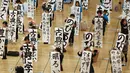 Siswa memperlihatkan tulisan mereka saat mengikuti kontes kaligrafi dalam merayakan tahun baru di Tokyo, Jepang, Selasa (5/1/2016). Lebih dari 3000 peserta menuliskan resolusi tahun baru di atas sebuah kanvas. (REUTERS / Thomas Peter)
