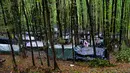 Migran berdiri di sekitar tenda yang dibuat seadanya di kamp darurat di hutan di luar Velika Kladusa, Bosnia pada 26 September 2020. Kebanyakan imigran dan pengungsi di Bosnia berasal dari Timur Tengah, Afrika dan Asia. (AP Photo/Kemal Softic)