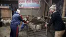 Sejumlah pria saat menimbang seekor kambing akan dijual disebuah pasar ternak di Kathmandu, Nepal, Kamis (15/10/2015).   Kambing - kambing ini akan dijual untuk dikorbankan dalam peringatan festival keagamaan ini. (REUTERS/Navesh Chitrakar)
