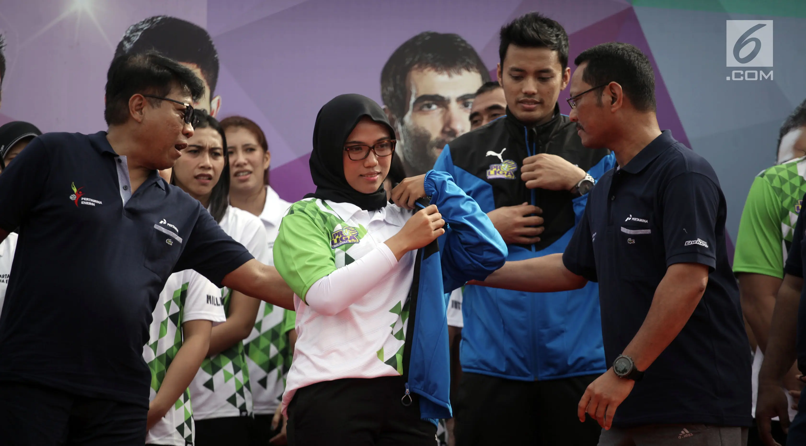 Direktur Manajemen Aset Pertamina Dwi Wahyu Daryoto mengenakan jaket kepada pemain putri saat Launching Tim Bola Voli Jakarta Pertamina Energi di Kantor Pusat Pertamina, Jakarta, Jumat (5/1).(/Arya Manggala)