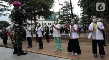 Tenaga kesehatan dan nonkesehatan bertepuk tangan selama 56 detik pada peringatan Hari Kesehatan Nasional ke-56 di RSD Wisma Atlet, Jakarta, Kamis (12/11/2020). Aksi tersebut sebagai bentuk penghargaan kepada tenaga kesehatan yang berjuang menghadapi pandemi COVID-19. (Liputan6.com/Herman Zakharia)