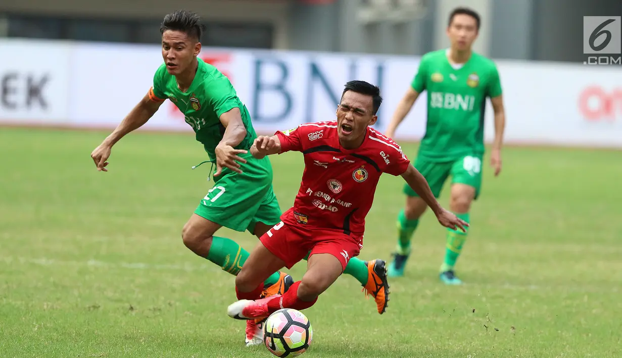 Penyerang Semen Padang, Adi Nugroho terjatuh saat berebut bola dengan bek Bhayangkara FC, Indra Kahfi di lanjutan Liga 1 Indonesia di Stadion Patriot Candrabhaga, Bekasi, Sabtu (20/5). Bhayangkara FC unggul 1-0. (Liputan6.com/Helmi Fithriansyah)