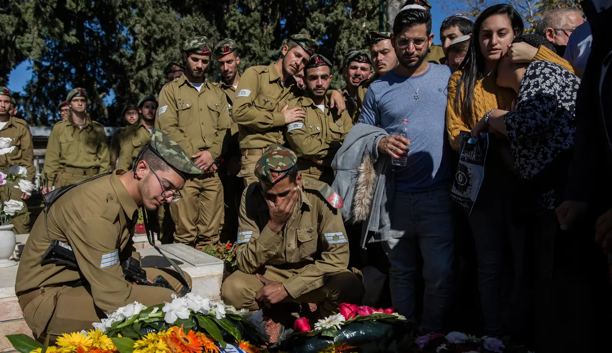 Teman dan keluarga tentara Israel yang tewas ditembak, Sersan Yovel Mor Yosef berduka saat pemakamannya di Ashkelon, Israel, Jumat (14/12). Yosef adalah salah satu dari dua tentara Israel yang tewas ditembak pria Palestina. (AP Photo/Tsafrir Abayov)