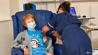 Margaret Keenan, 90 tahun, pasien pertama di Inggris yang menerima vaksin Pfizer-BioNTech COVID-19, diberikan oleh perawat May Parsons di University Hospital, Coventry, Inggris, 8 Des 2020. (Jacob King / Pool via AP)