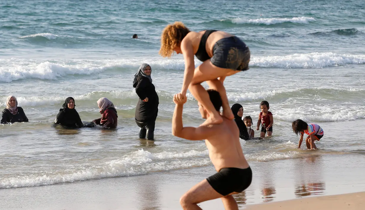 Sejumlah wanita muslim terlihat di Pantai Laut Mediterania, Tel Aviv, Israel pada 22 Agustus 2016. Saat pengunjung pantai mengenakan busana yang minim mereka tetap mengenakan jilbab dan busananya. (REUTERS / Baz Ratner)