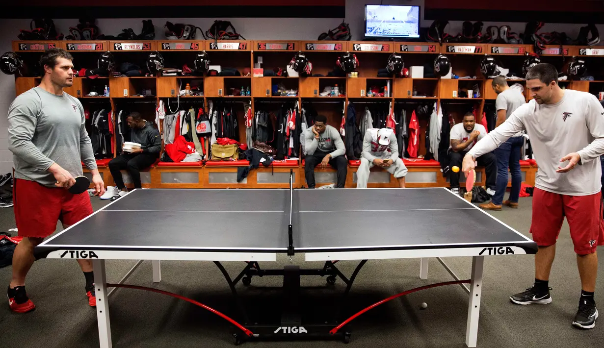 Pemain Atlanta Falcons, Andy Levitre (kiri) bermain tenis meja dengan rekan setimnya Josh Harris di ruang ganti di fasilitas latihan NFL football di Flowery Branch, Ga (26/1). Sebelum bertanding para pemain bermain tenis meja. (AP Photo/David Goldman)