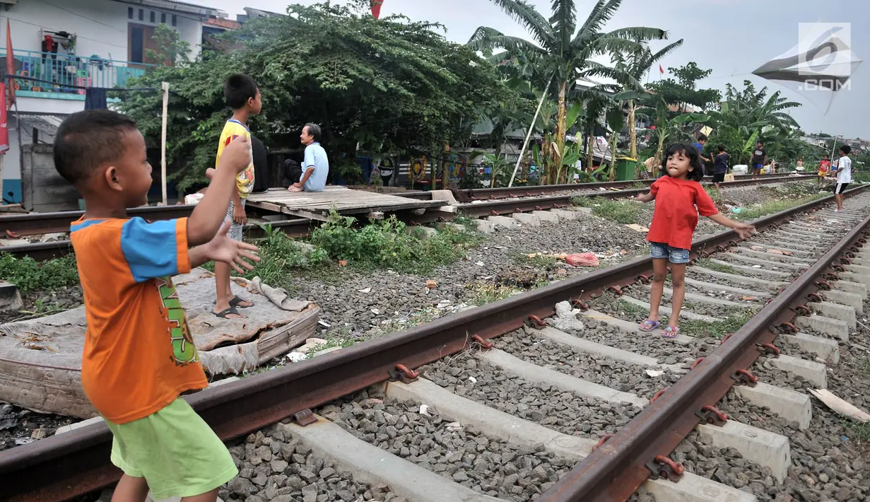 Anak-anak bermain layang-layang di rel kereta api kawasan Jakarta Timur, Kamis (3/1). Rel yang sering dilintasi kereta api tersebut sangat membahayakan diri mereka. (Merdeka.com/Iqbal Nugroho)
