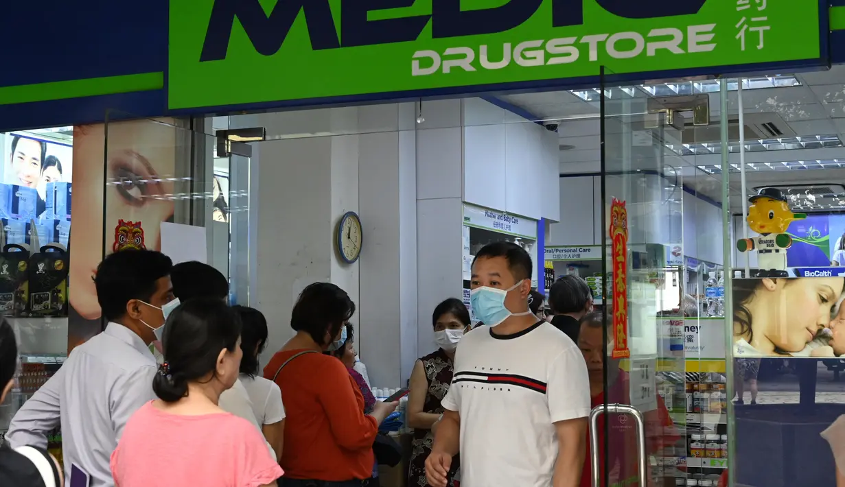 Warga mengantre di luar apotek untuk membeli masker, termometer, dan pembersih tangan di Singapura (29/1/2020). Singapura sejauh ini mengonfirmasi tujuh kasus virus corona - semuanya datang dari Wuhan. (AFP Photo/Roslan Rahman)