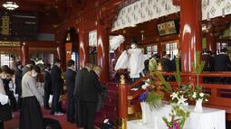 Seorang pendeta berdoa untuk umat pada hari kerja pertama tahun ini di Kuil Kanda Myojin di Tokyo pada 4 Januari 2023. Pekerja dari sekitar 2.500 perusahaan membuat reservasi untuk mengunjungi kuil pada 4 dan 5 Januari saja, kata seorang pejabat kuil. (AFP/Kazuhiro Nogi)