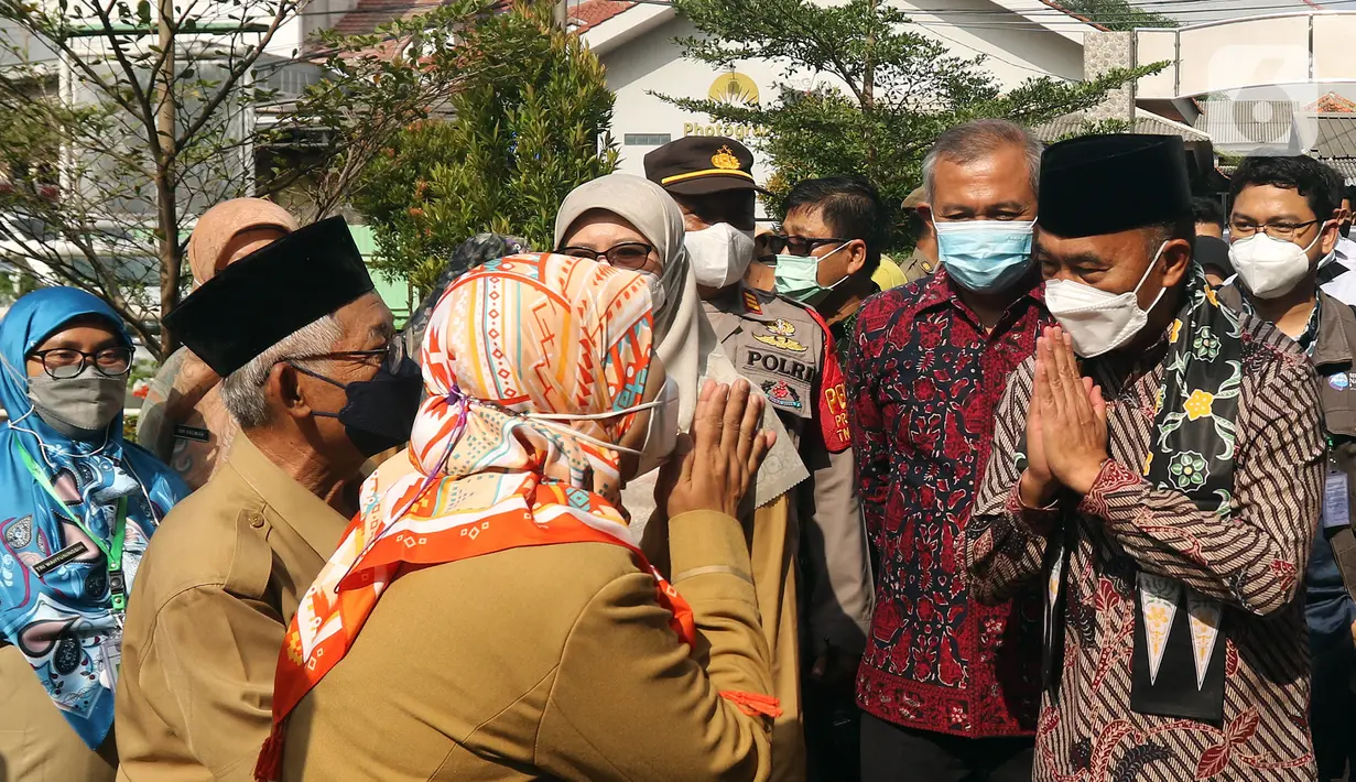 Menko PMK Muhadjir Effendy (kanan) menyapa para guru saat meninjau vaksinasi COVID-19 di SDN 01 Depok, Depok, Jawa Barat, Selasa (14/12/2021). Kunjungan tersebut untuk melihat persiapan vaksinasi COVID-19 anak usia 6-11 tahun yang dilaksanakan mulai hari ini. (Liputan6.com/Herman Zakharia)