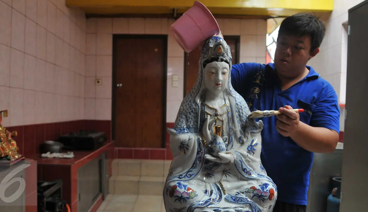 Seorang umat membersihkan patung dewa-dewi saat ritual cuci dewa di Klenteng Dharma Bhakti,Jakarta, minggu, (31/1). Pencucian sejumlah patung ini dilakukan guna menyambut tahun baru imlek China 2567. (Liputan6.com/Gempur M Surya)