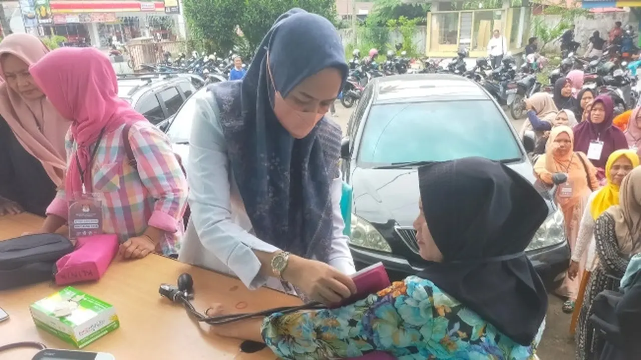 Petugas kesehatan dari Polresta Pekanbaru mengecek tensi dan memberikan vitamin kepada pekerja pelipatan surat suara Komisi Pemilihan Umum.
