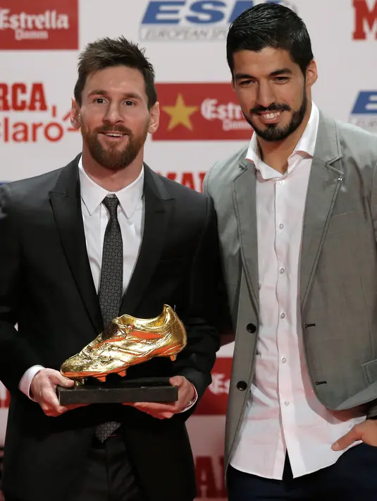 Penyerang Barcelona, Lionel Messi berpose dengan Luis Suarez usai meraih sepatu emas di Barcelona, Spanyol (24/11). Messi meraih sepatu emas pada 2010,2012,2013. (AP Photo/Manu Fernandez)