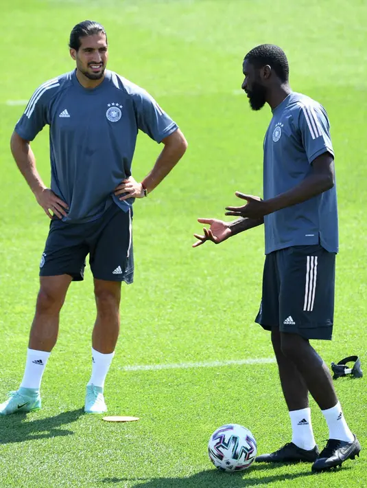 Pemain Jerman Emre Can (kiri) berbicara dengan Antonio Ruediger saat sesi latihan MD-1 di Herzogenaurach, Jerman, Senin (28/6/2021). Jerman akan melawan Inggris pada babak 16 besar Euro 2020. (Christof STACHE/AFP)
