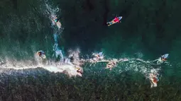 Pantai ini menjadi destinasi bagi wisatawan yang mencari ketenangan serta keindahan alam yang tak tertandingi. Tampak dalam foto, pemandangan udara menunjukkan para peselancar menunggangi ombak di pantai Lhoknga, provinsi Aceh, pada Senin 12 Januari 2026. (CHAIDEER MAHYUDDIN/AFP)