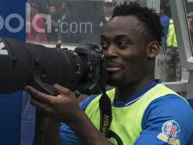Gelandang Persib Bandung, Michael Essien, mencoba kamera milik wartawan sebelum laga uji coba melawan Bali United di Stadion GBLA Bandung, Jawa Barat, Sabtu (8/4/2017). (Bola.com/Vitalis Yogi Trisna)