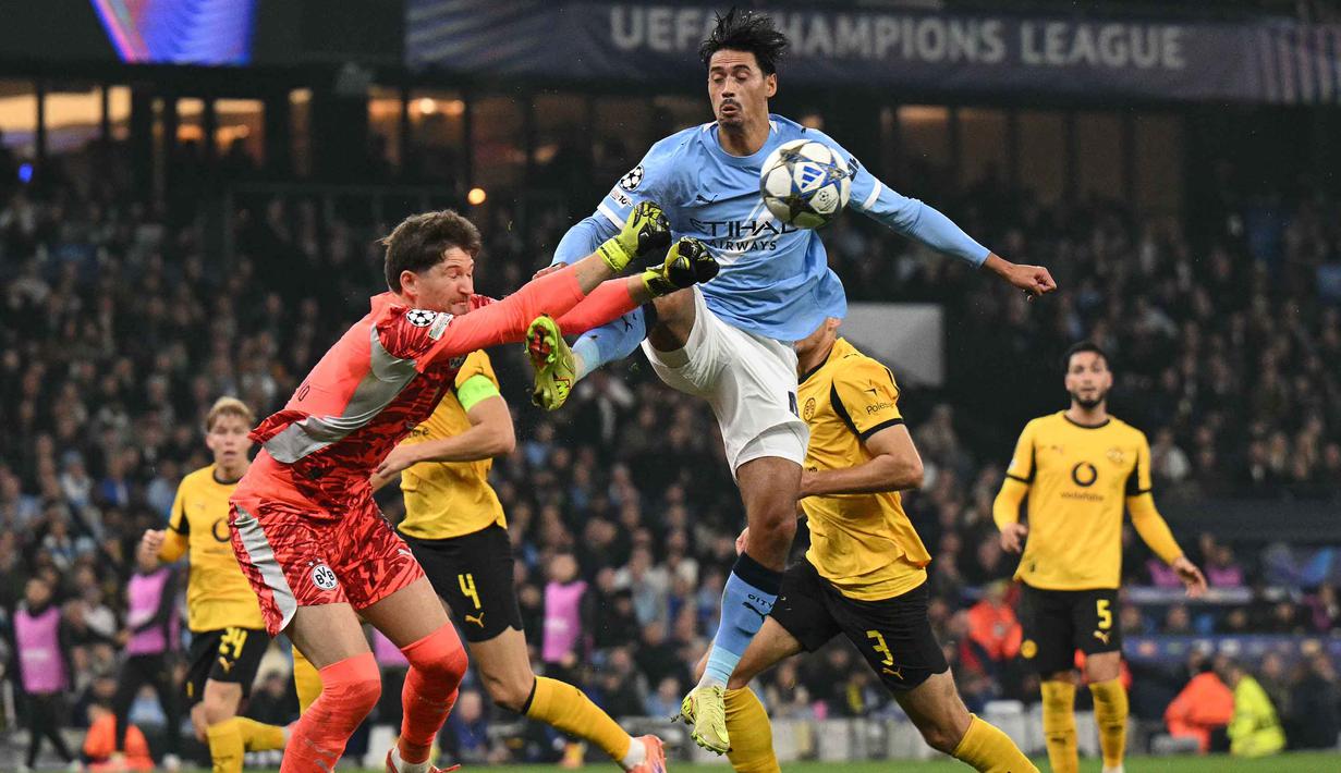 Berstatus sebagai tuan rumah, The Citizens langsung menguasai permainan sejak awal laga melalui kombinasi apik di lini tengah. Tampak dalam foto, kiper Dortmund asal Swiss, Gregor Kobel (kiri) menahan sepakan gelandang Manchester City asal Belanda, Tijjani Reijnders dalam pertandingan lanjutan fase liga Liga Champions 2025/2026 antara Manchester City dan Borussia Dortmund di Stadion Etihad, Manchester, Inggris barat laut, pada 5 November 2025 waktu setempat atau Kamis (6/11) dini hari WIB. (Oli SCARFF/AFP)