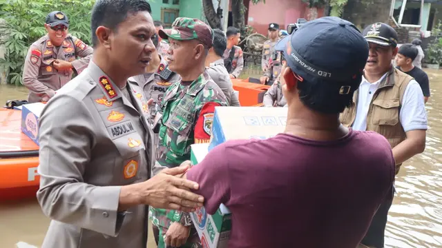 Kapolres Metro Depok, Kombes Abdul Waras membantu mengevakuasi dan memberikan bantuan kepada warga terdampak bajir di Perumahan Sawangan Asri, Sawangan, Depok.