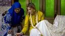 Ratu Maxima dari Belanda (kanan), dalam kapasitasnya sebagai Advokat Khusus Sekretaris Jenderal PBB untuk Keuangan Inklusif untuk Pembangunan (UNSGSA), mencoba membatik di Kampung Batik Laweyan, Surakarta, Jawa Tengah, pada Selasa 25 November 2025. Ratu Belanda, Maxima Zorreguieta Cerruti, mengunjungi Kampung Batik Laweyan, Surakarta, Jawa Tengah, Selasa (25/11/2025). (DEVI RAHMAN/AFP)