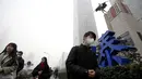 Sejumlah warga berjalan mengenakan masker saat beraktivitas di distrik Beijing pusat bisnis, Tiongkok, (21/12). Kabut asap akibat polusi udara yang melanda sebagian kota-kota di Tiongkok membuat warga beraktivitas mengunakan masker. (Reuters/Jason Lee)