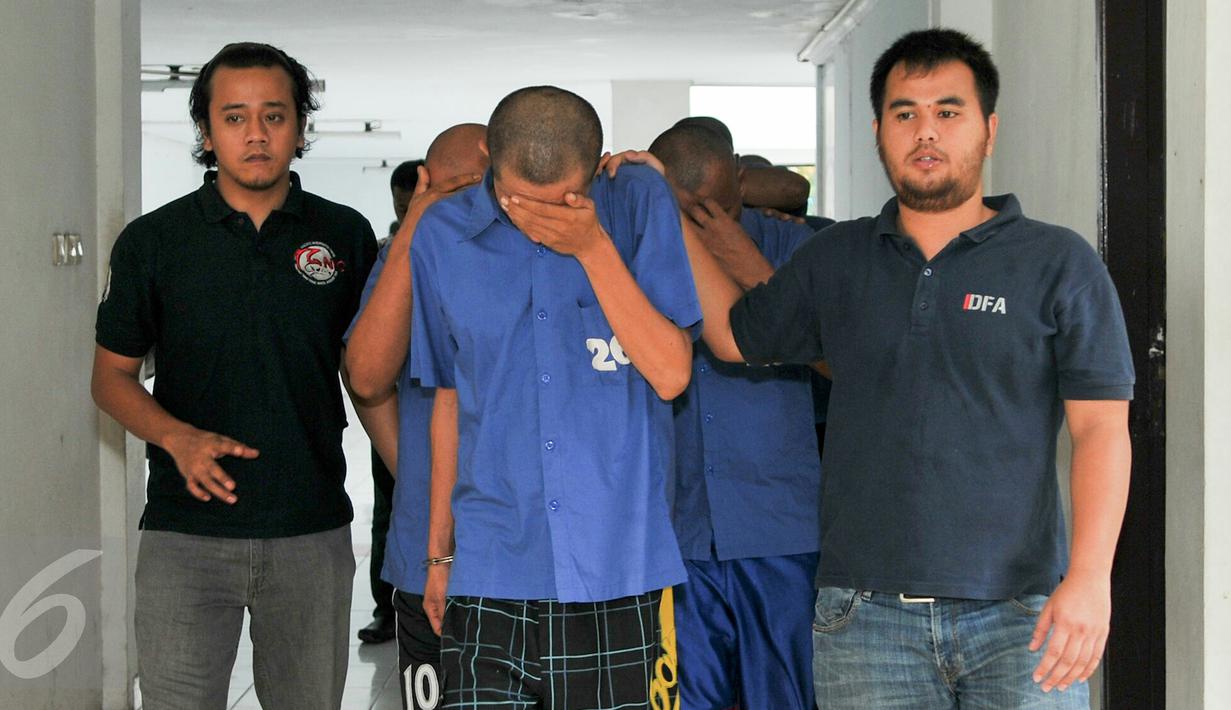 Para tersangka digiring ke tahanan usai rilis kasus di Mako Ditnarkoba Mabes Polri, Jakarta, Jumat (19/2). Petugas menangkap 7 orang tersangka sindikat narkotika internasional dan menyita 40 ribu butir ekstasi senilai Rp24 M. (Liputan6.com/Yoppy Renato)