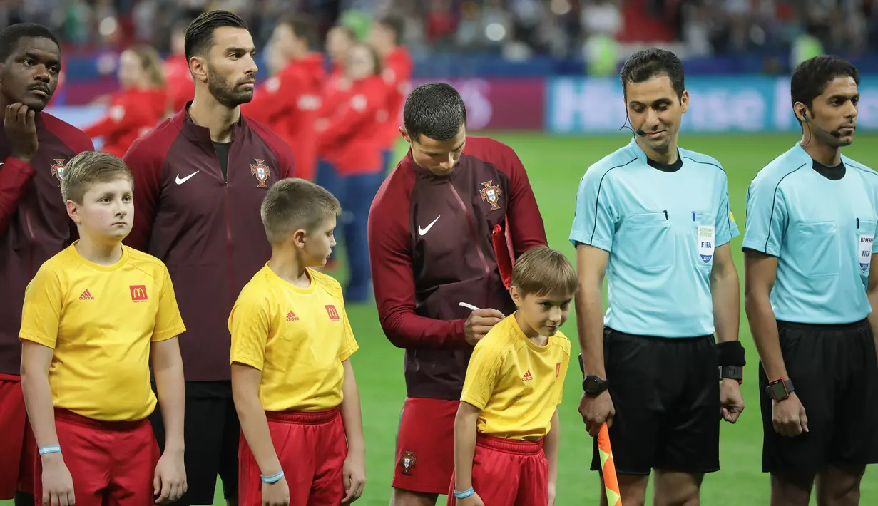 Bintang Portugal, Cristiano Ronaldo, memberikan tanda tangan kepada seorang anak sebelum laga semifinal Piala Konfederasi melawan Cile di Stadion Kazan Arena, Kazan, Rabu (28/6/2017). (EPA/Mario Cruz) 