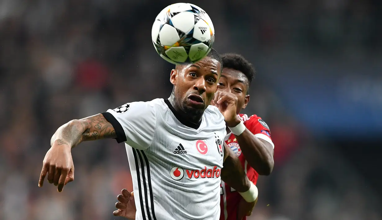 Gelandang Besiktas Jeremain Lens berebut bola dengan bek Bayern Munchen David Alaba saat pertandingan Liga Champions leg kedua di stadion Vodafone Arena di Istanbul (14/3). (AFP/Bulent Kilic)