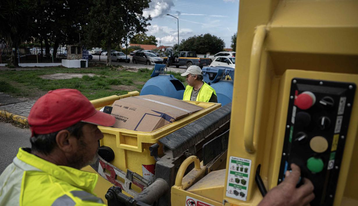 Masalah ini disebabkan oleh kapasitas yang terbatas dan sering terjadi penumpukan sampah, meskipun ada upaya daur ulang yang sedang dilakukan. Tampak dalam foto, pekerja pemerintah daerah mengumpulkan bahan daur ulang di desa Acharavi, pulau Corfu, pada 15 Oktober 2025. (Angelos TZORTZINIS/AFP)