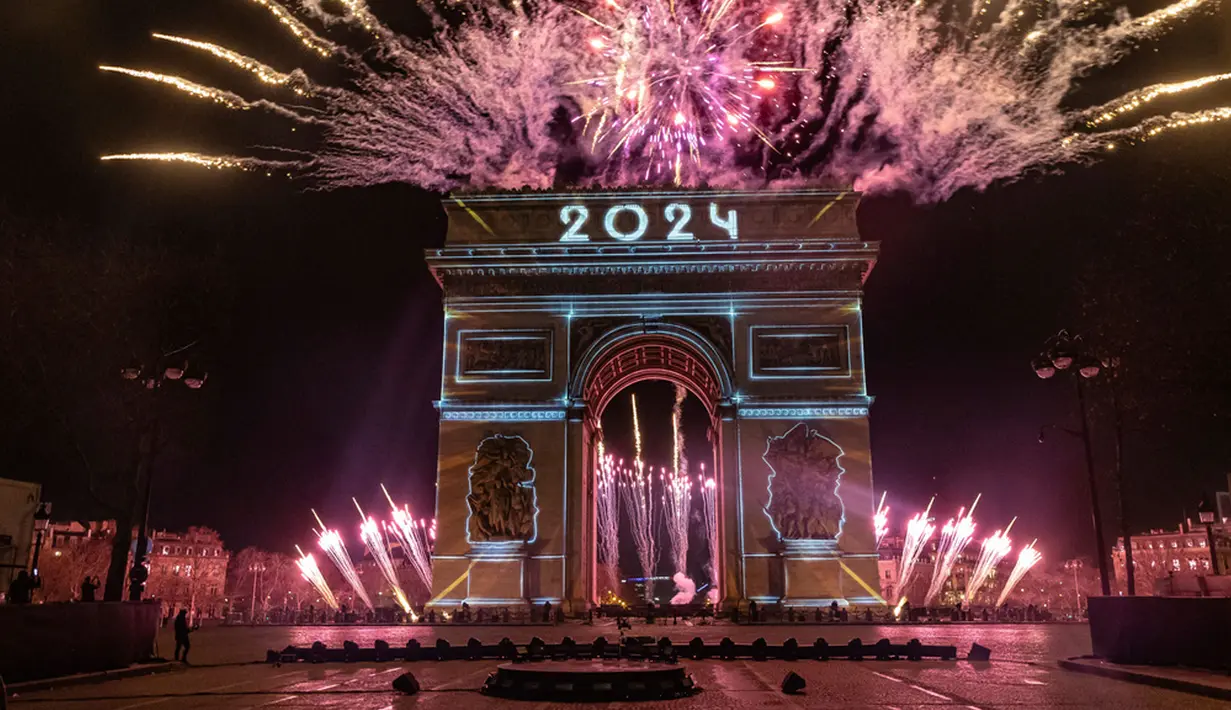 Pertunjukan cahaya diproyeksikan di Arc de Triomphe saat perayaan Tahun Baru di Champs Elysees, Paris, Prancis, Senin (1/1/2024). (AP Photo/Aurelien Morissard)