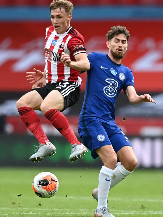 Pemain Sheffield United, Ben Osborn berebut bola gelandang Chelsea, Jorginho pada pekan ke-35 Liga Inggris di Bramall Lane, Minggu (12/7/2020) dini hari WIB. Chelsea dihajar 0-3 oleh Sheffield United. (Shaun Botterill/Pool via AP)