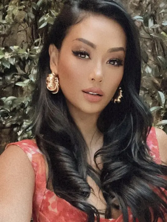 Rambutnya panjangnya dibiarkan teurai, dengan riasan mata coklat serasi dengan highlighter dan lipstiknya. Ia juga mengenakan aksesori keemasannya. (@indahkalalo)