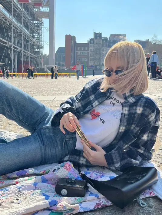 Gaya santai Lisa Blackpink satu ini mungkin bisa dijadikan sebagai inspirasi. Menggunakan celan denim yang dipadukan kaos putih serta kemeja kotak-kotak, kacamata hitam serta handbag dan kamera pun menjadi pelengkap yang sempurna. (Liputan6.com/IG/@lalalalisa_m)